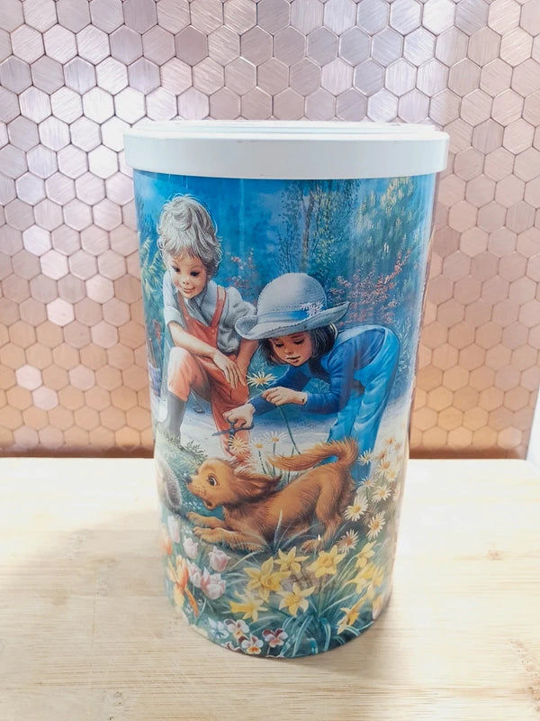 Lot de deux anciennes boîtes à biscuits cylindriques en métal lithographié de l'univers de l'héroïne de livres Martine, illustrations de Marcel Marlier datant des années 1990, parfaites pour le rangement décoratif de la chambre d'enfant.