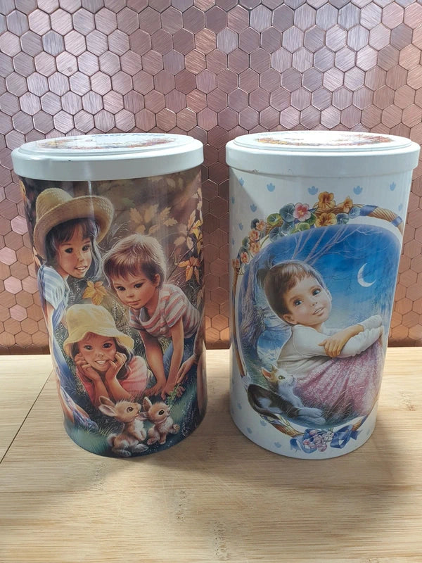 Lot de deux anciennes boîtes à biscuits cylindriques en métal lithographié de l'univers de l'héroïne de livres Martine, illustrations de Marcel Marlier datant des années 1990, parfaites pour le rangement décoratif de la chambre d'enfant.