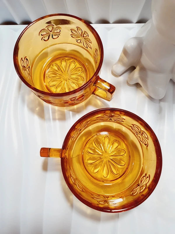 Duo de grandes tasses à café ou thé de couleur ambrée transparente en verre épais trempé, décoré de motifs de fleurs marguerites moulés en relief, marque Vereco France époque années 1970.