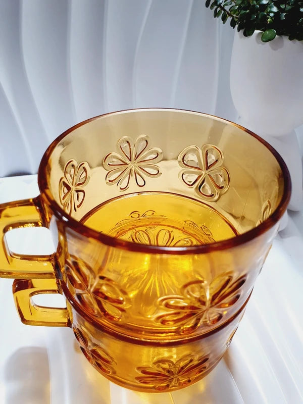 Lot de six tasses à café espresso empilables en verre trempé ambré transparent, ornées d'un motif de fleurs marguerites "Daisy" moulé en relief, marque Vereco France époque années 1970.