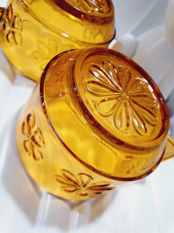 Lot de six tasses à café espresso empilables en verre trempé ambré transparent, ornées d'un motif de fleurs marguerites "Daisy" moulé en relief, marque Vereco France époque années 1970.