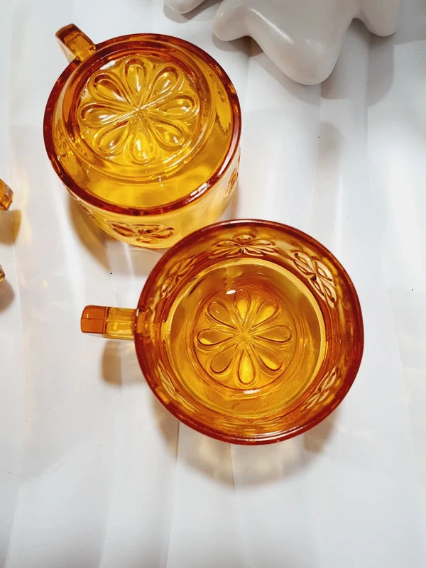 Lot de six tasses à café espresso empilables en verre trempé ambré transparent, ornées d'un motif de fleurs marguerites "Daisy" moulé en relief, marque Vereco France époque années 1970.