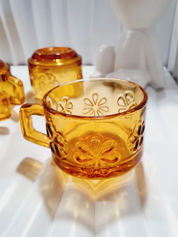 Lot de six tasses à café espresso empilables en verre trempé ambré transparent, ornées d'un motif de fleurs marguerites "Daisy" moulé en relief, marque Vereco France époque années 1970.