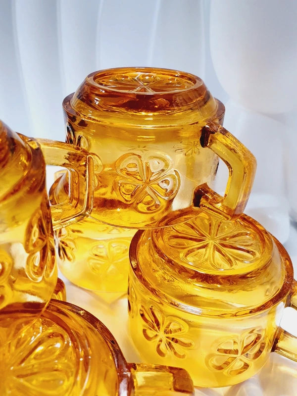 Lot de six tasses à café espresso empilables en verre trempé ambré transparent, ornées d'un motif de fleurs marguerites "Daisy" moulé en relief, marque Vereco France époque années 1970.