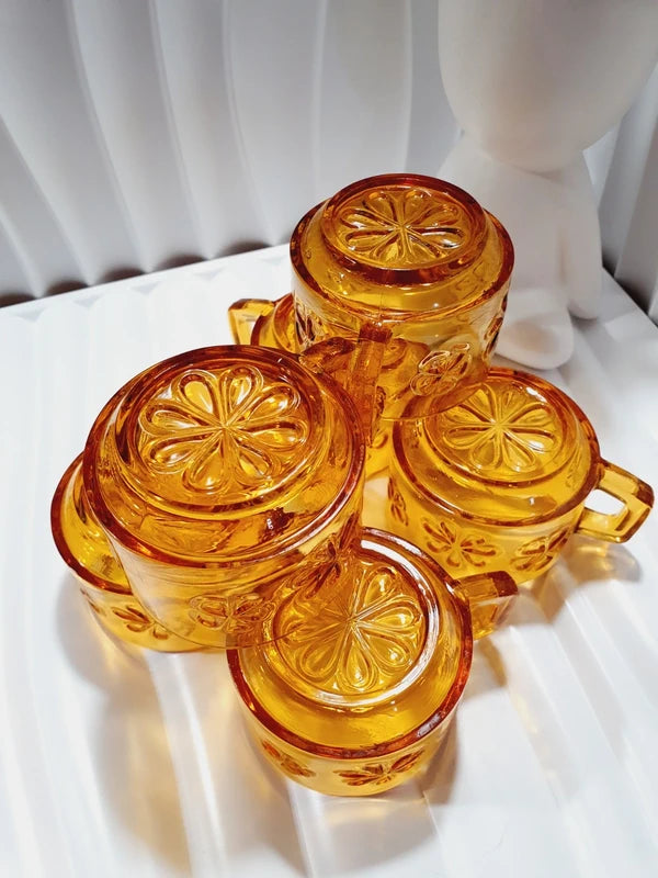 Lot de six tasses à café espresso empilables en verre trempé ambré transparent, ornées d'un motif de fleurs marguerites "Daisy" moulé en relief, marque Vereco France époque années 1970.