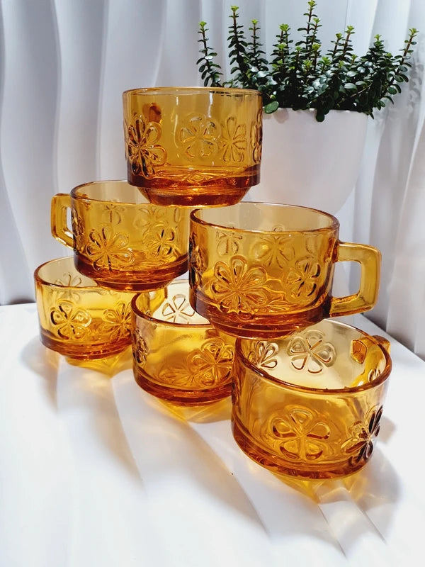 Lot de six tasses à café espresso empilables en verre trempé ambré transparent, ornées d'un motif de fleurs marguerites "Daisy" moulé en relief, marque Vereco France époque années 1970.