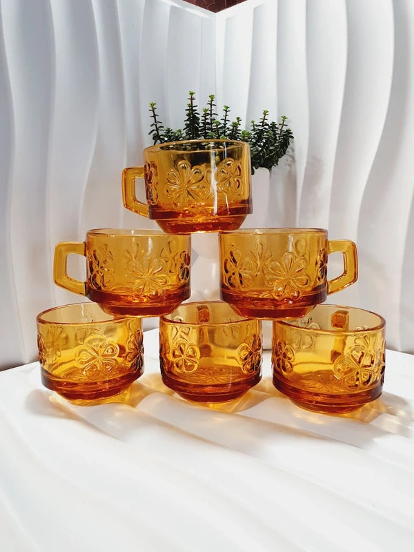 Lot de six tasses à café espresso empilables en verre trempé ambré transparent, ornées d'un motif de fleurs marguerites "Daisy" moulé en relief, marque Vereco France époque années 1970.