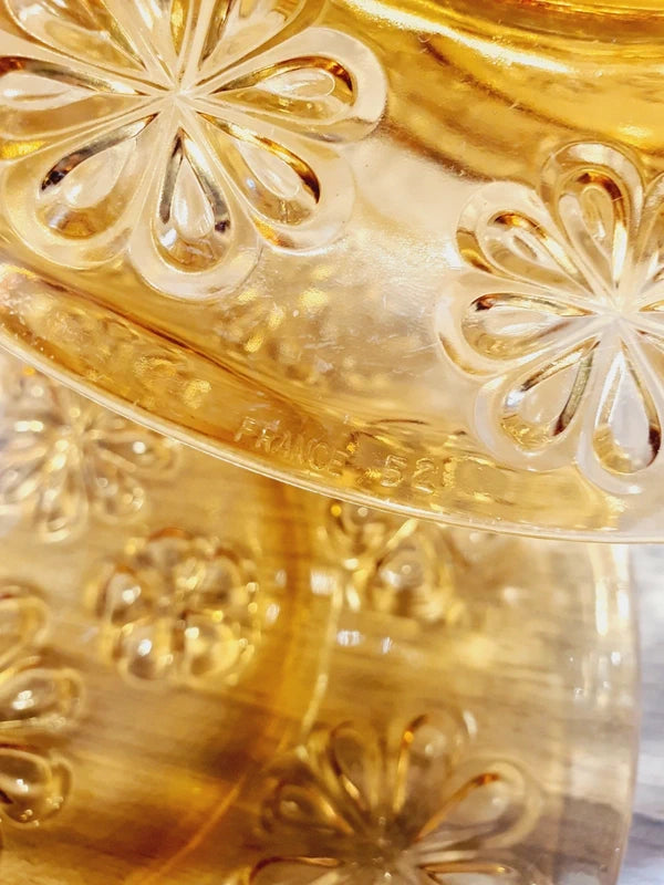 Lot de six assiettes plates rondes à dessert en verre trempé épais de couleur ambrée transparente, ornées d'un motif de fleurs marguerites moulé en relief sur l'extérieur, de la marque française Vereco époque années 1970.