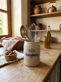 Petite choppe à bière en grès gris et bleu cobalt avec logo Kronenbourg en relief, fabriquée en Allemagne, style traditionnel rustique. Utilisé comme pot à ustensiles de cuisine dans une cuisine campagne.